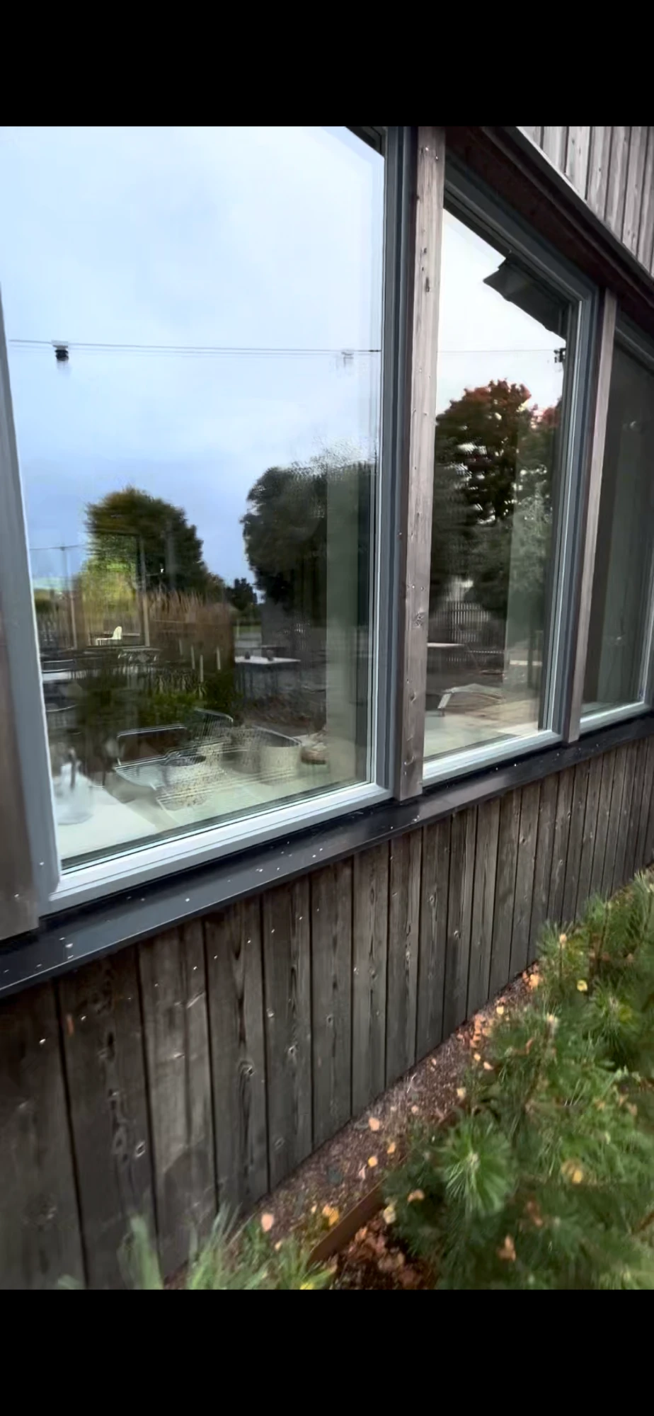 Stora skyltfönster i mörk träfasad efter putsning